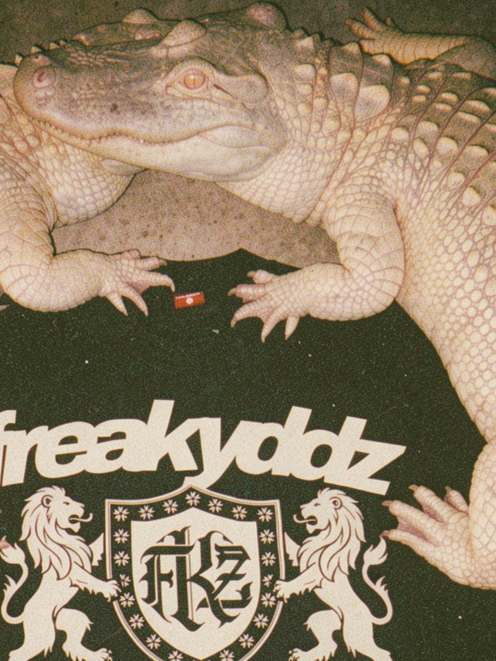 Primer plano de un caimán albino junto al logotipo FREAKYDDZ estampado